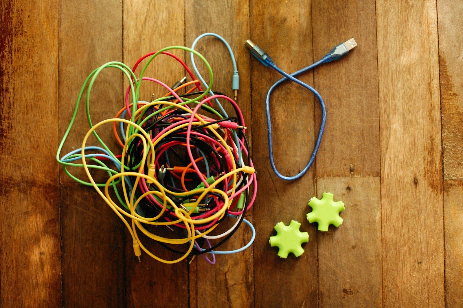 a bunch of wires and a pair of scissors on a wooden floor